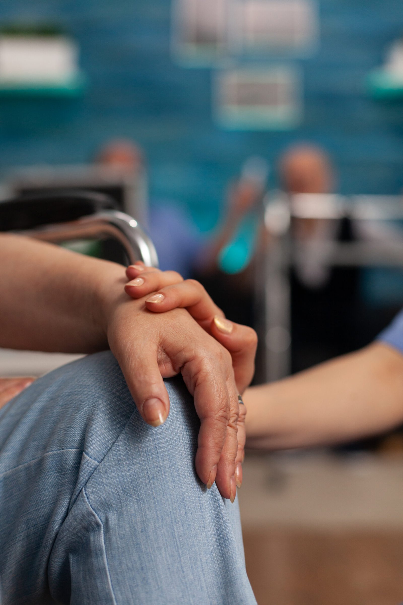 Female patient in wheelchair being assisted by nurse